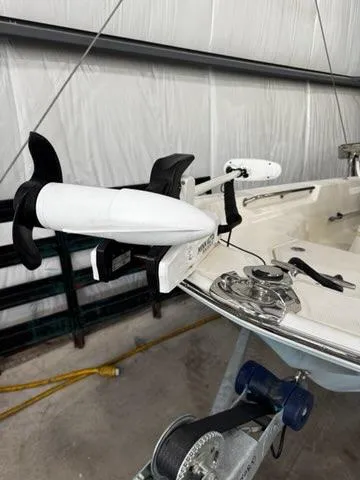 Slide: The Image of 2021 Boston Whaler 150 Montauk boat with mounted trolling motor in storage. - 13