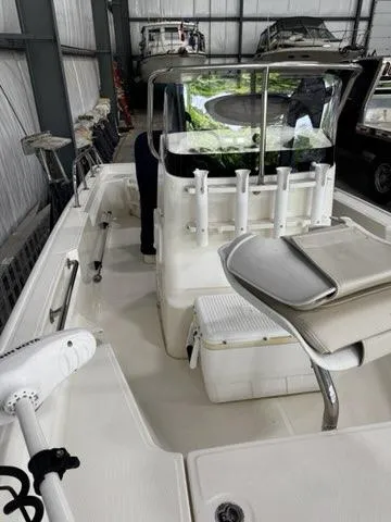 Slide: The Image of 2021 Boston Whaler 150 Montauk boat in storage, featuring fishing rod holders and seating. - 16