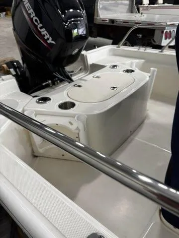 Slide: The Image of 2021 Boston Whaler 150 Montauk boat interior with Mercury engine, showcasing seating and storage. - 17