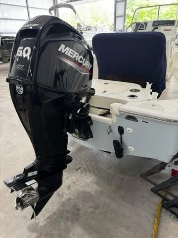 Slide: The Image of 2021 Boston Whaler 150 Montauk with Mercury 50 HP outboard engine in a garage setting. - 4