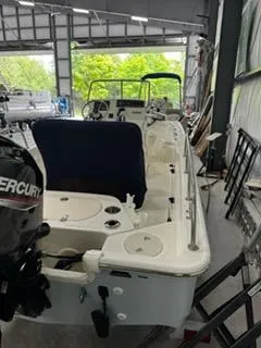 Slide: The Image of 2021 Boston Whaler 150 Montauk boat in a garage, featuring a Mercury engine. - 5