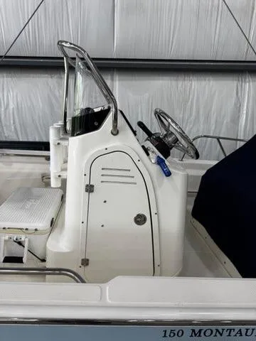 Slide: The Image of 2021 Boston Whaler 150 Montauk boat interior with steering console and seating. - 7
