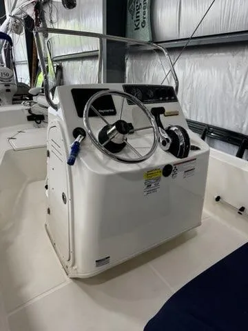 Slide: The Image of 2021 Boston Whaler 150 Montauk boat console with steering wheel and controls in a storage area. - 8
