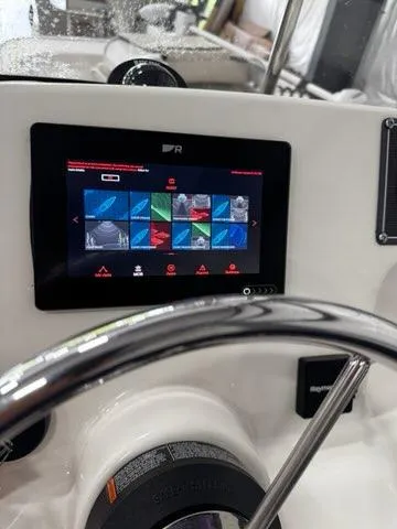 Slide: The Image of 2021 Boston Whaler 150 Montauk dashboard with touchscreen display and steering wheel. - 9