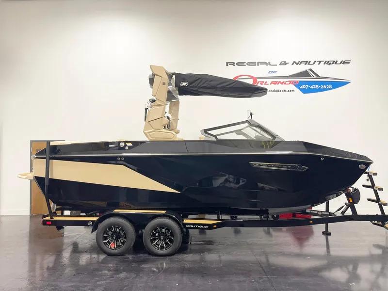 The Image of 2025 Nautique Super Air Nautique G25 boat on trailer in showroom. - 1