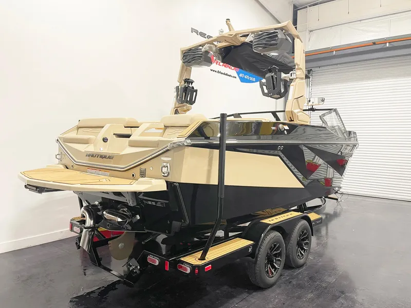 Slide: The Image of 2025 Nautique Super Air Nautique G25 boat on trailer in showroom. - 3