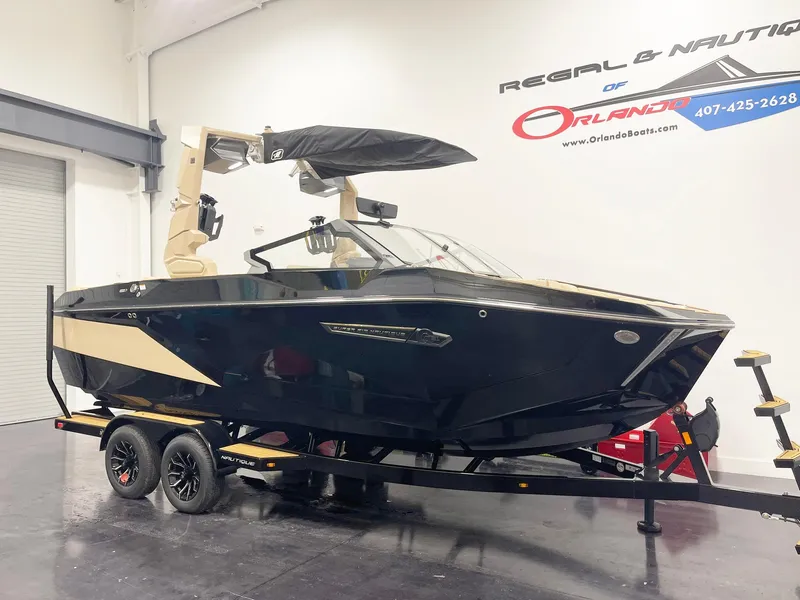 Slide: The Image of 2025 Nautique Super Air Nautique G25 boat on trailer in showroom. - 2