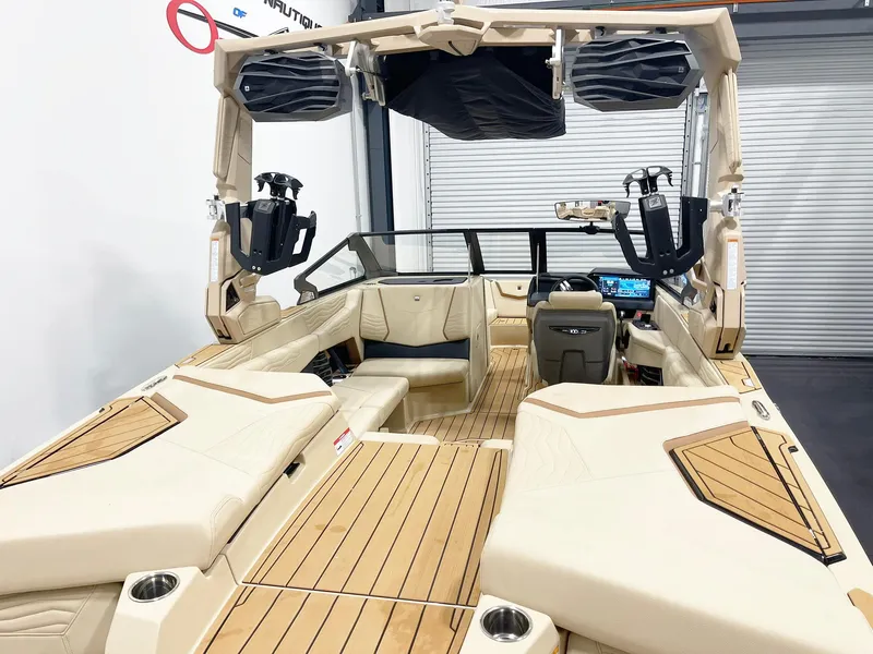 Slide: The Image of 2025 Nautique Super Air Nautique G25 interior with beige seating and advanced dashboard. - 4