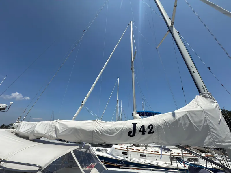 Slide: The Image of Sailboat J/42 by J Boats, 1998 model, with covered sails under a clear blue sky. - 12