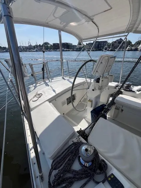 Slide: The Image of 1998 J Boats J/42 sailboat cockpit with steering wheel, ropes, and waterfront view. - 17