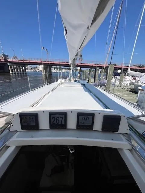 Slide: The Image of 1998 J Boats J/42 sailboat deck with navigation instruments, docked near a bridge. - 23