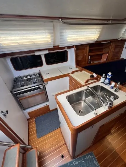 Slide: The Image of Interior of 1998 J Boats J/42 sailboat featuring a compact kitchen with sink and stove. - 25