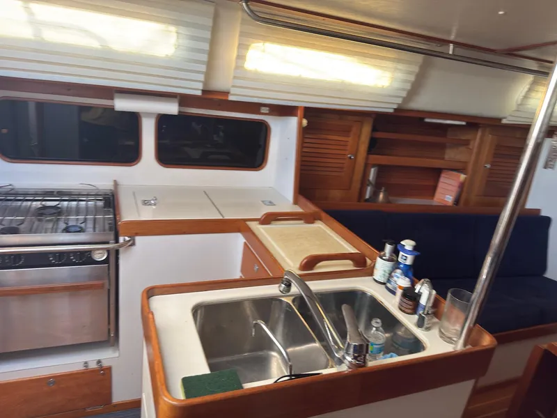 Slide: The Image of Interior of 1998 J Boats J/42 sailboat, featuring kitchen and seating area. - 26
