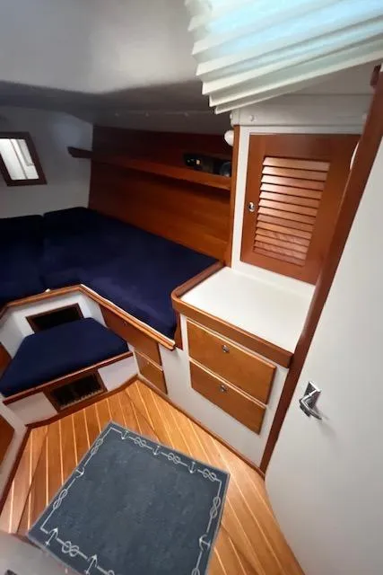 Slide: The Image of Interior of 1998 J Boats J/42 sailboat with wooden cabinetry and blue seating. - 31