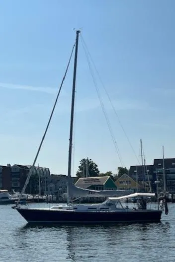 Slide: The Image of 1998 J Boats J/42 sailboat on calm water near a marina. - 5