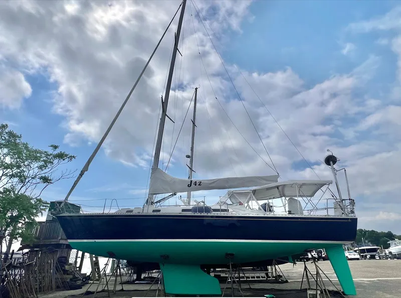 Slide: The Image of 1998 J Boats J/42 sailboat on stands, under a partly cloudy sky. - 8