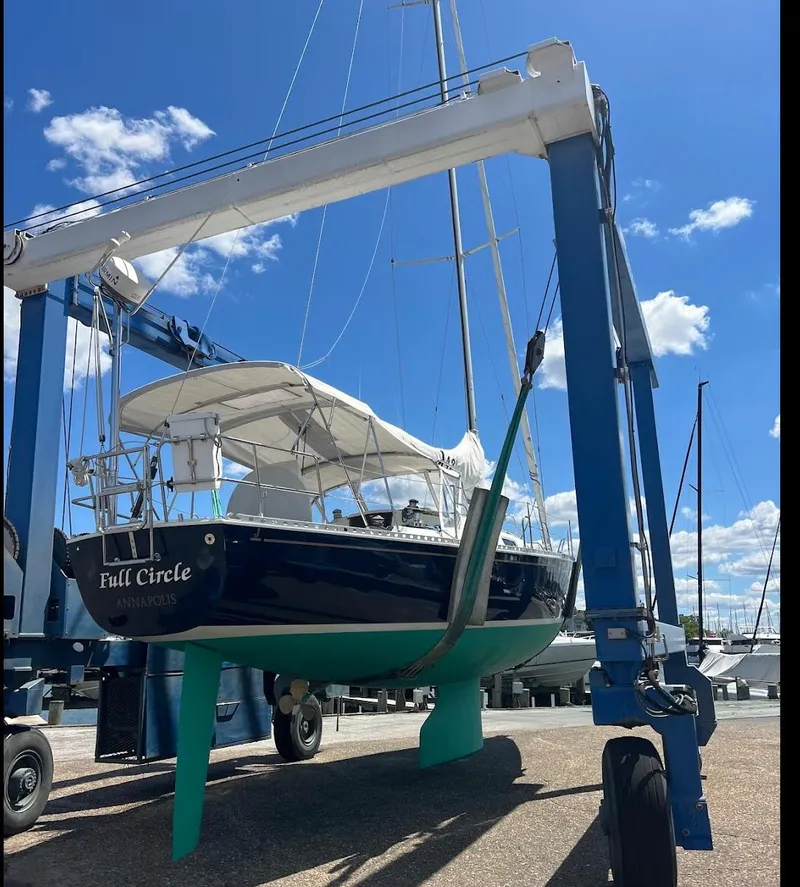 Slide: The Image of Sailboat J/42 from 1998 in a boatyard lift under a clear blue sky. - 9