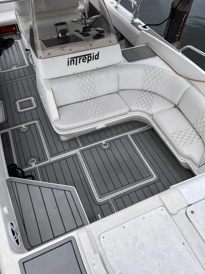 Slide: The Image of 1996 Intrepid 370 Cuddy boat interior with white seating and gray flooring. - 11