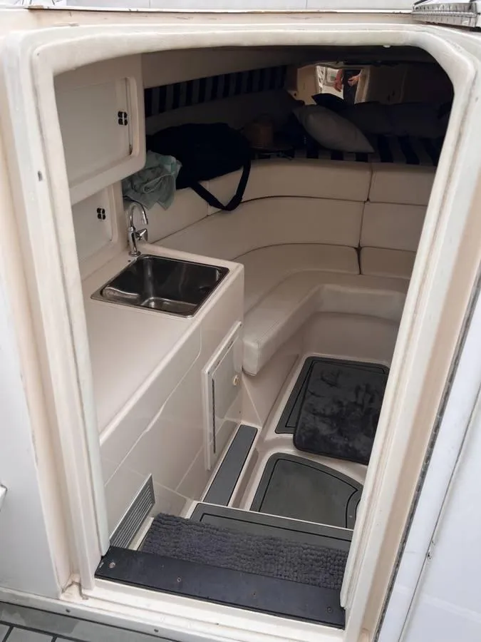 Slide: The Image of 1996 Intrepid 370 Cuddy cabin interior with sink and seating area. - 13