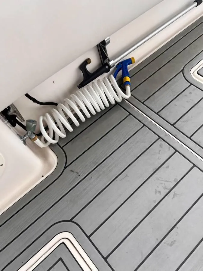 Slide: The Image of Deck of 1996 Intrepid 370 Cuddy with coiled hose and non-slip flooring. - 17