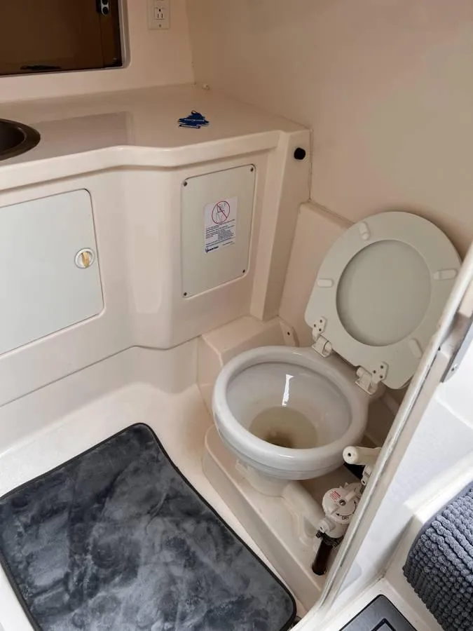 Slide: The Image of 1996 Intrepid 370 Cuddy boat bathroom with toilet and sink area. - 19