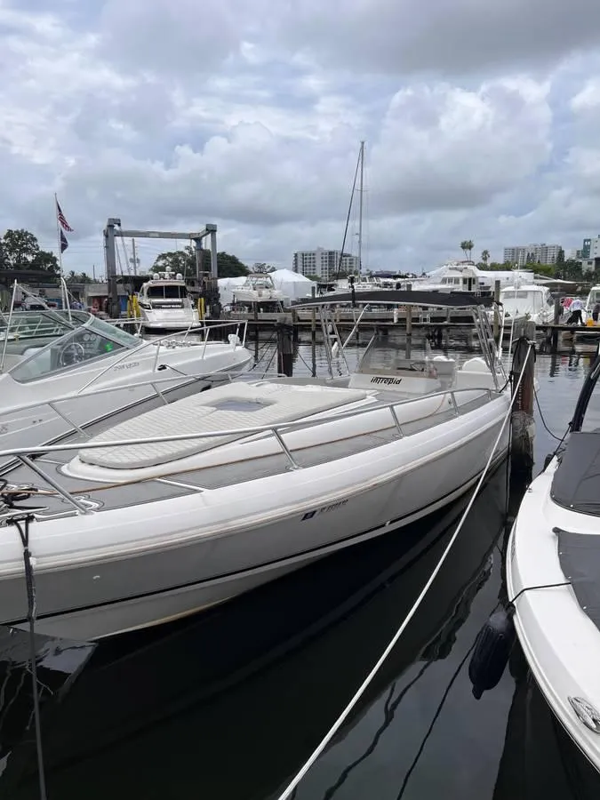Slide: The Image of 1996 Intrepid 370 Cuddy boat docked at a marina under cloudy skies. - 4