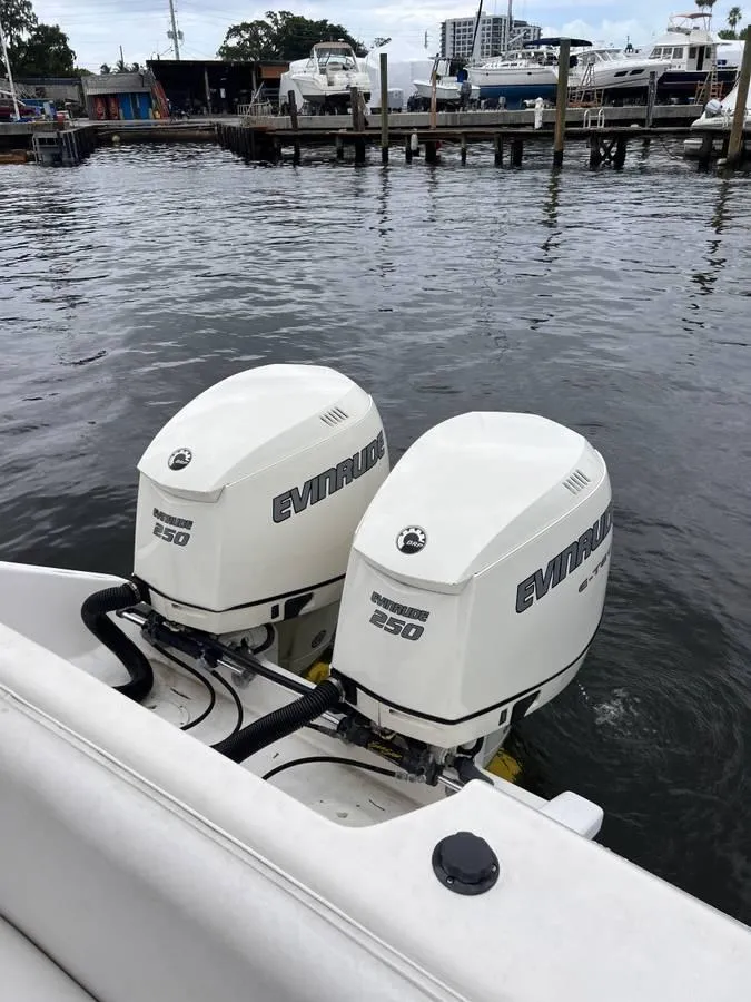 Slide: The Image of Twin Evinrude 250 outboard motors on a 1996 Intrepid 370 Cuddy at a marina. - 7