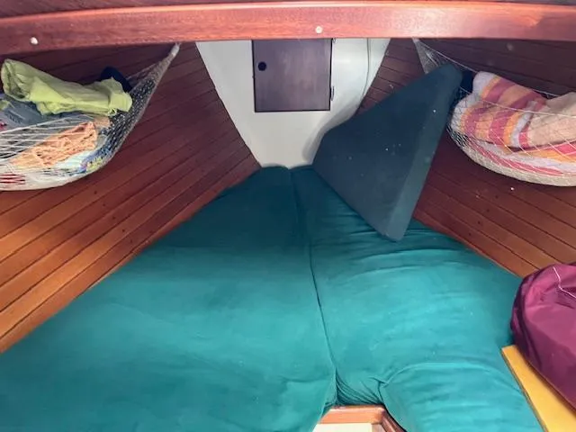 Slide: The Image of Interior cabin of a 1979 Morris Leigh 30 sailboat with green cushions and wooden paneling. - 1