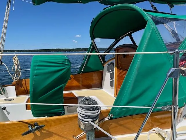 Slide: The Image of 1979 Morris Leigh 30 sailboat with green canopy on calm water. - 10