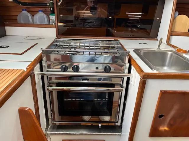 Slide: The Image of 1979 Morris Leigh 30 yacht kitchen with stove, sink, and wooden cabinetry. - 4