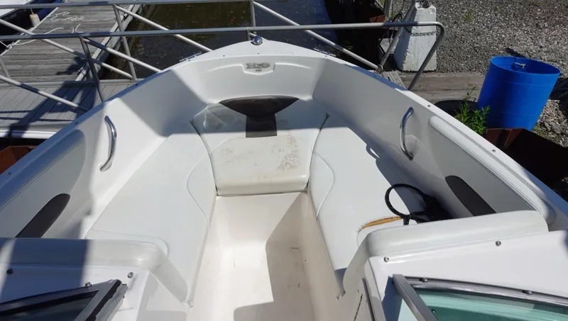 Slide: The Image of 2013 Chaparral 19 Sport H2O boat interior with white seating and metal railings. - 8