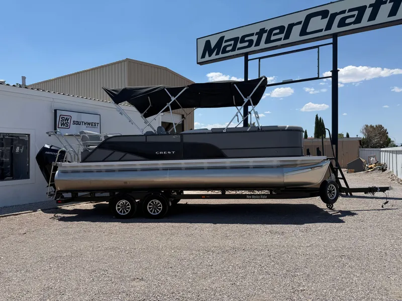 The Image of 2024 Crest Classic DLX 240 SLRC pontoon boat on trailer at dealership. - 1