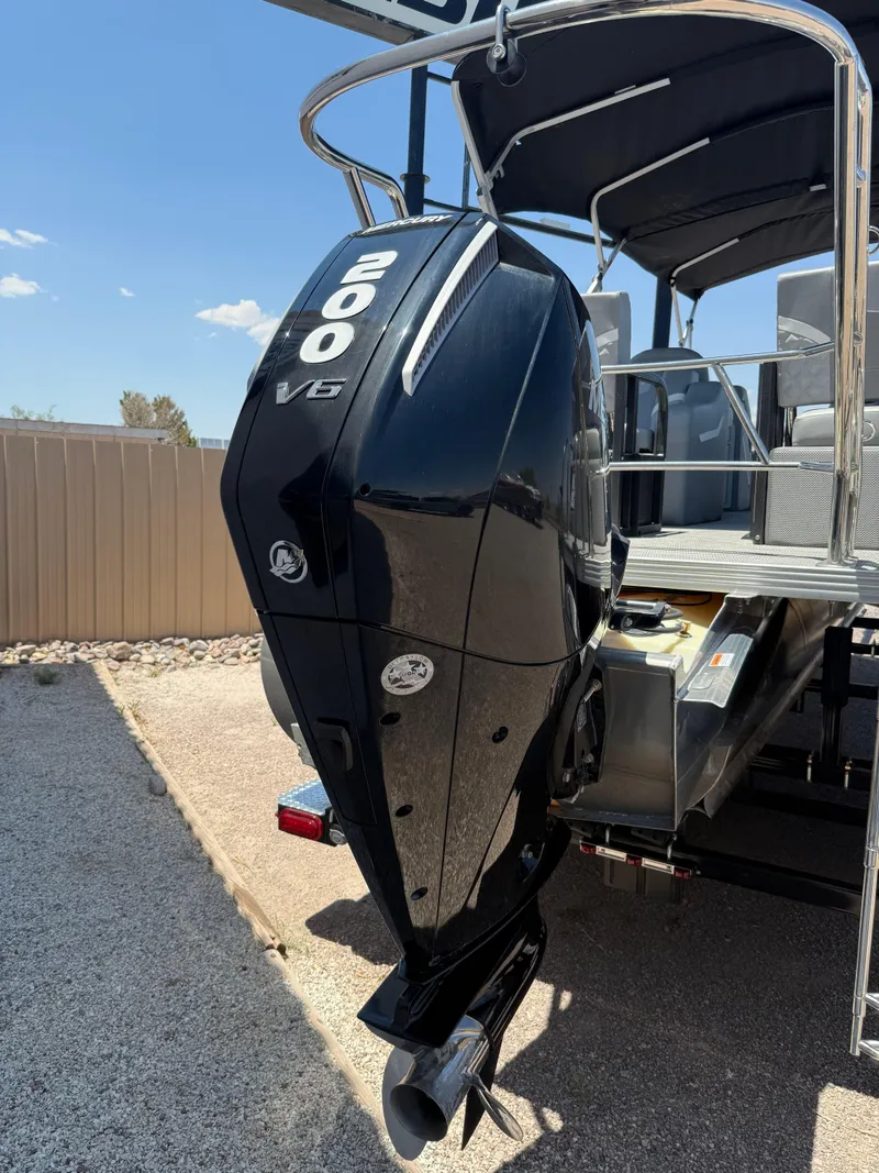 Slide: The Image of 2024 Crest Classic DLX 240 SLRC boat with powerful 200 V6 engine, parked outdoors. - 10