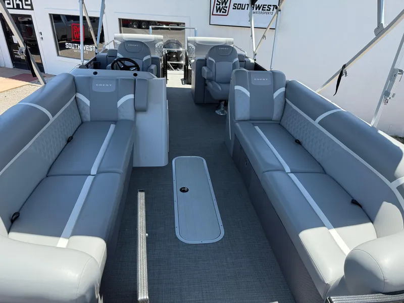 Slide: The Image of 2024 Crest Classic DLX 240 SLRC pontoon boat interior with gray seating and steering console. - 12