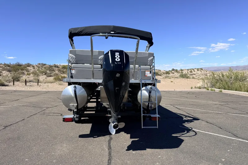 Slide: The Image of 2024 Crest Classic DLX 240 SLRC pontoon boat with 200 V6 engine, parked outdoors. - 14