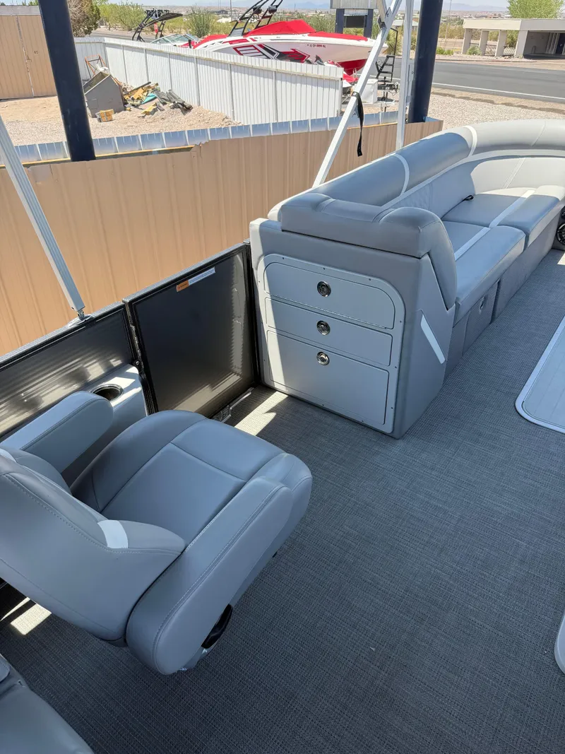 Slide: The Image of 2024 Crest Classic DLX 240 SLRC boat interior with gray seating and carpeted floor. - 8