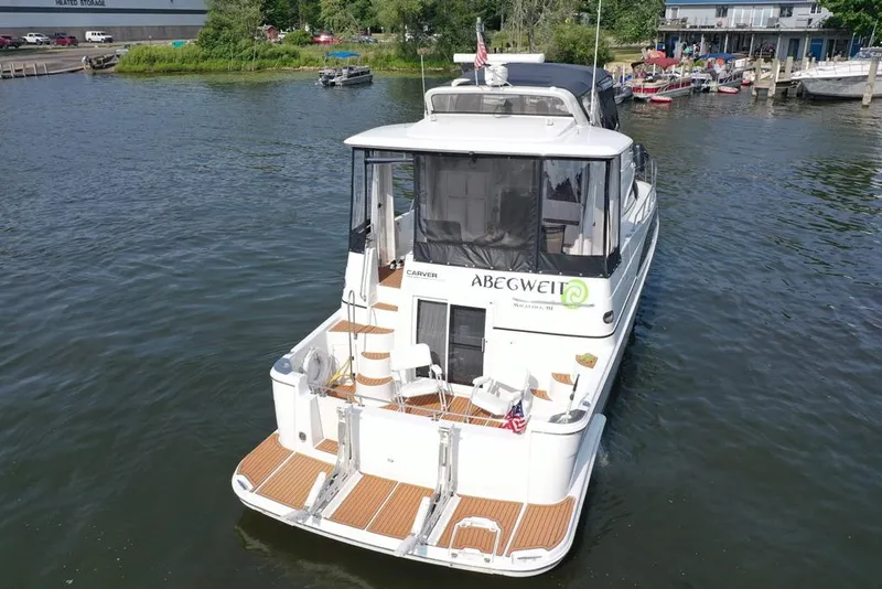 Slide: The Image of 2003 Carver 444 Cockpit Motor Yacht on water, rear view, docked near marina. - 10