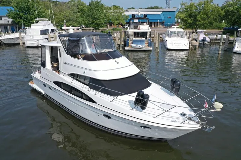 Slide: The Image of 2003 Carver 444 Cockpit Motor Yacht docked in a marina, surrounded by other boats. - 13