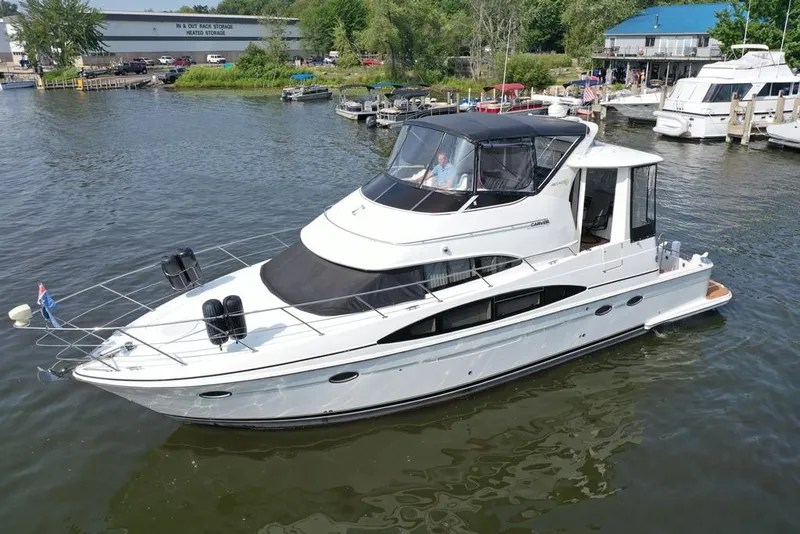 Slide: The Image of 2003 Carver 444 Cockpit Motor Yacht on a calm marina, surrounded by other boats. - 14