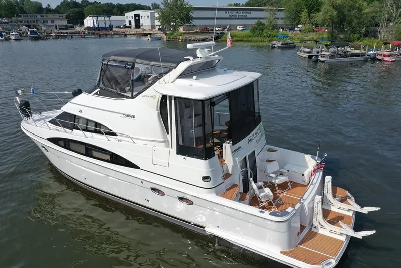 Slide: The Image of 2003 Carver 444 Cockpit Motor Yacht on a serene waterfront, showcasing elegant design. - 17