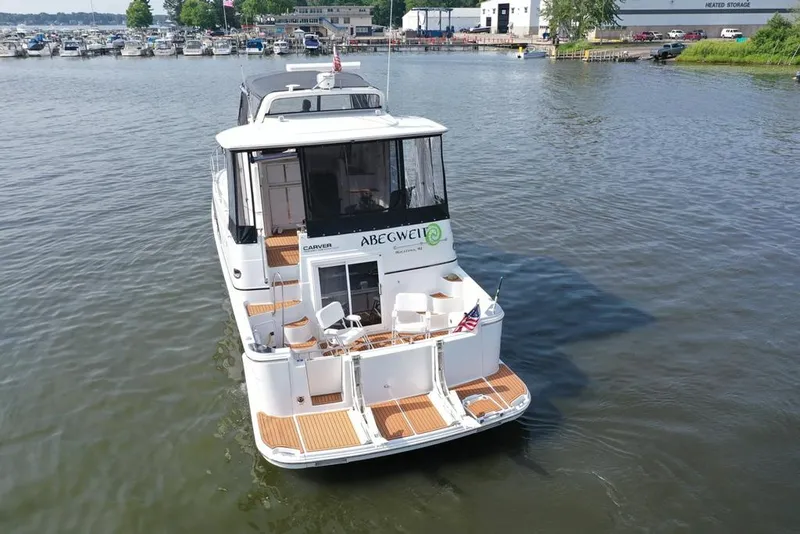 Slide: The Image of 2003 Carver 444 Cockpit Motor Yacht on calm water near marina. - 19