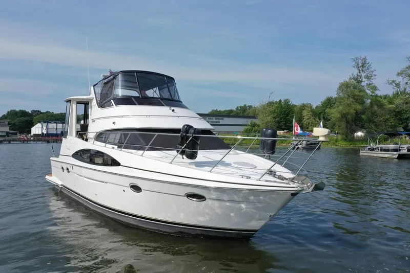 Slide: The Image of 2003 Carver 444 Cockpit Motor Yacht on calm water, surrounded by greenery. - 2