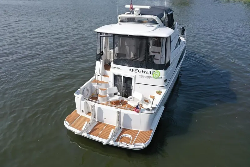Slide: The Image of 2003 Carver 444 Cockpit Motor Yacht on water, rear view, featuring spacious deck. - 21