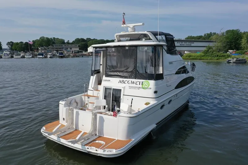 Slide: The Image of 2003 Carver 444 Cockpit Motor Yacht docked in a serene marina setting. - 22