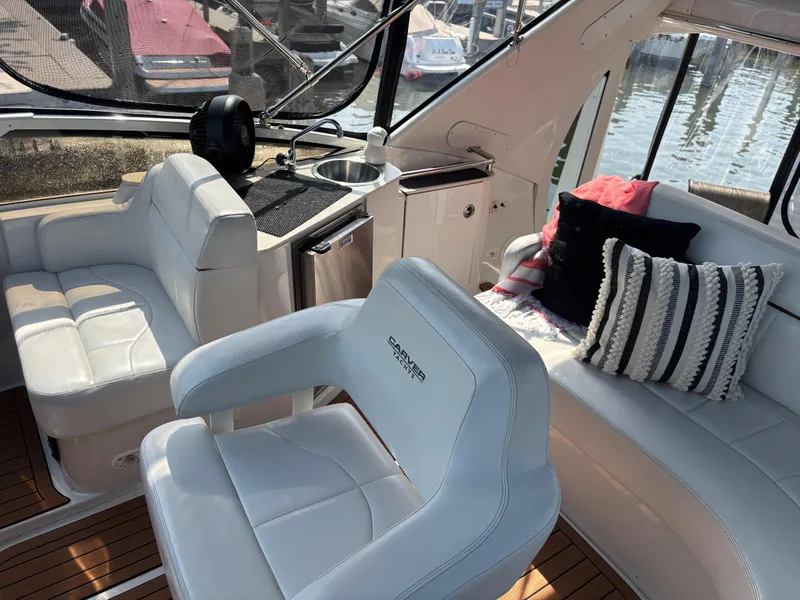 Slide: The Image of Interior of 2003 Carver 444 Cockpit Motor Yacht with white seating and striped pillows. - 25