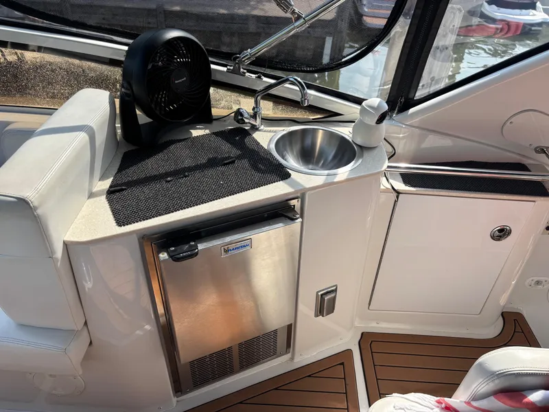 Slide: The Image of 2003 Carver 444 Cockpit Motor Yacht interior with sink, fan, and mini fridge. - 27