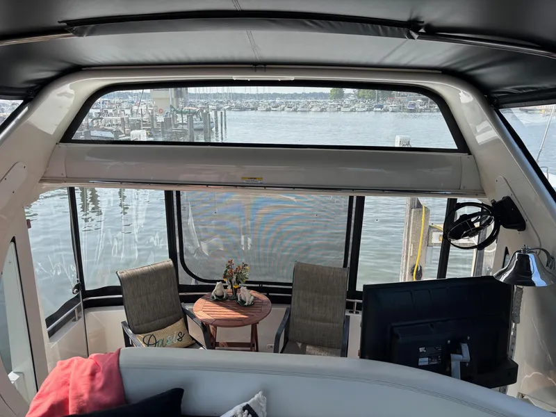 Slide: The Image of Interior view of 2003 Carver 444 Cockpit Motor Yacht with seating and marina backdrop. - 28