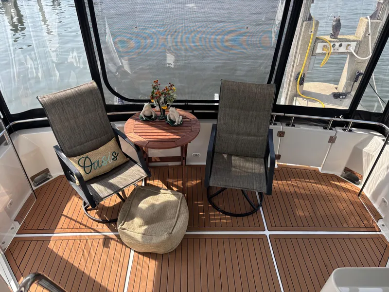 Slide: The Image of 2003 Carver 444 Cockpit Motor Yacht interior with chairs, table, and decorative items. - 29