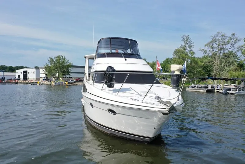 Slide: The Image of 2003 Carver 444 Cockpit Motor Yacht on calm water near marina. - 3