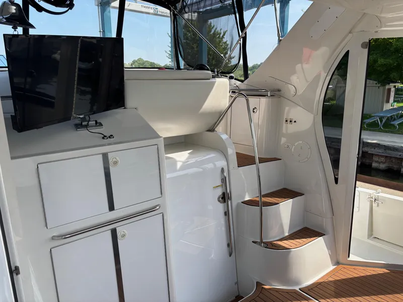 Slide: The Image of 2003 Carver 444 Cockpit Motor Yacht interior with stairs, TV, and storage cabinets. - 30